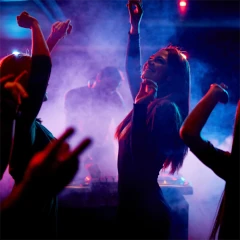 Grupa osób tańcząca w klubie przy kolorowych światłach