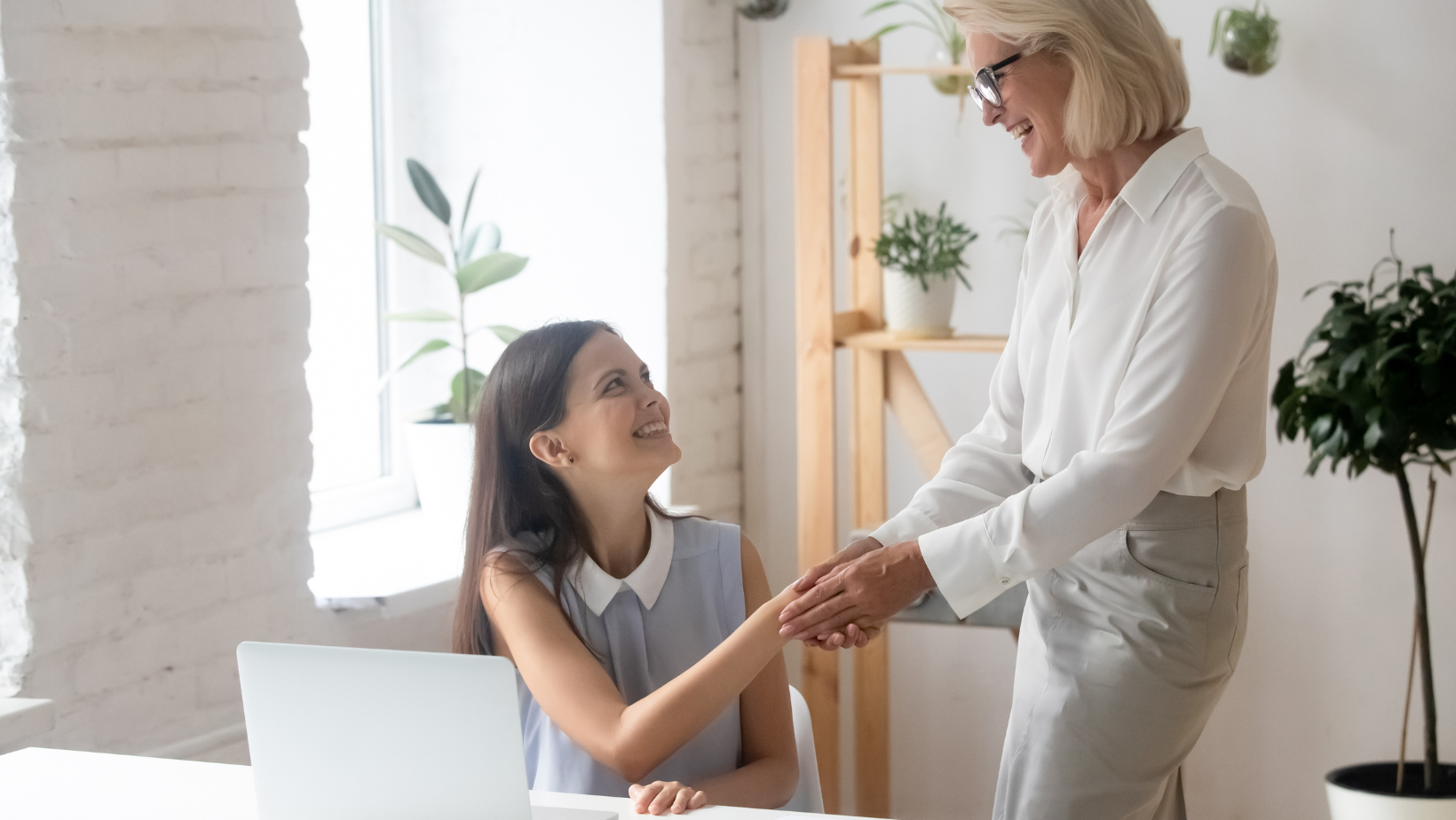 Dwie kobiety podające sobie dłoń w biurze