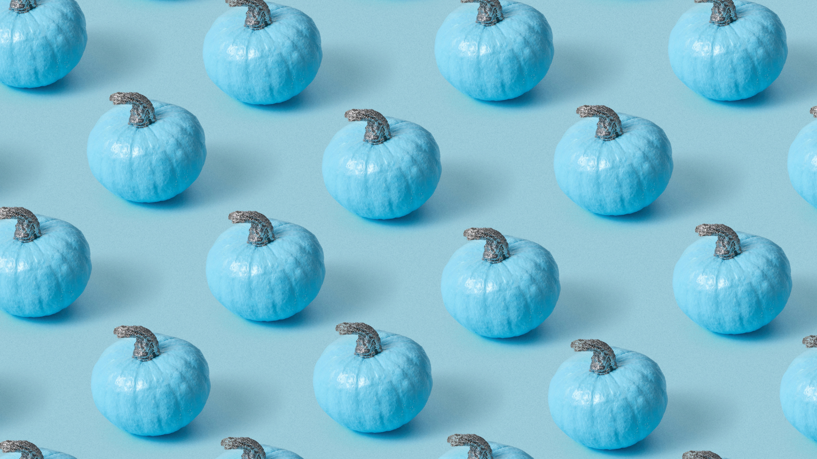 Wzór złożony z niebieskich dyń ustawionych w równych rzędach na jasnoniebieskim tle