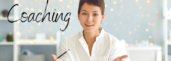 Drewniane kostki układające się w napis „COACHING” na tle mapy