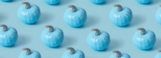 Wzór złożony z niebieskich dyń ustawionych w równych rzędach na jasnoniebieskim tle